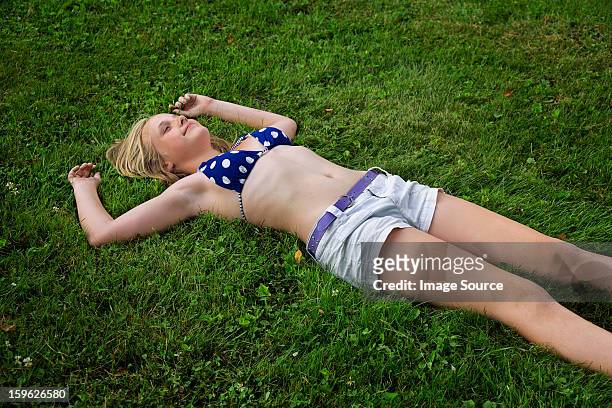 girl lying on grass, high angle - 13 year old girls in shorts stock pictures, royalty-free photos & images