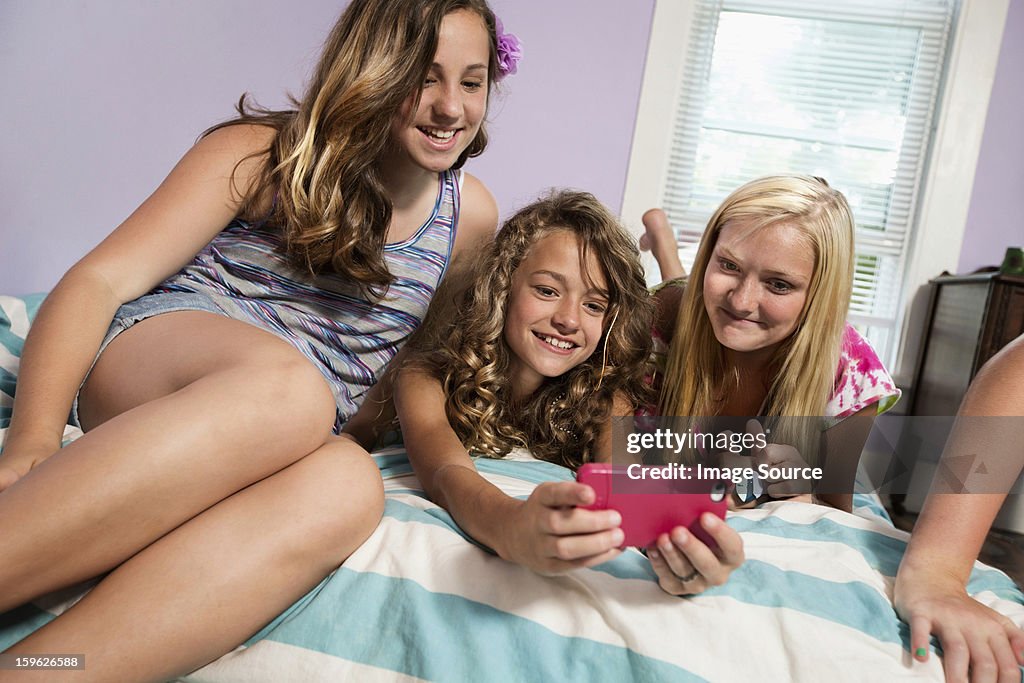 Girls using smartphone in bedroom
