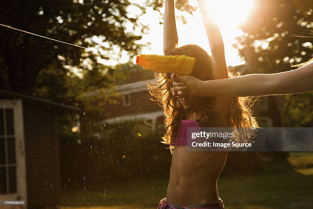 Girls having water fight with water pistols