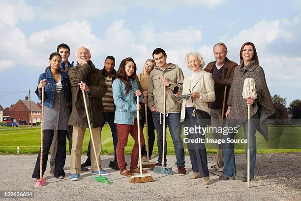 group of people standing with brooms and mop - holding broom stock pictures, royalty-free photos & images