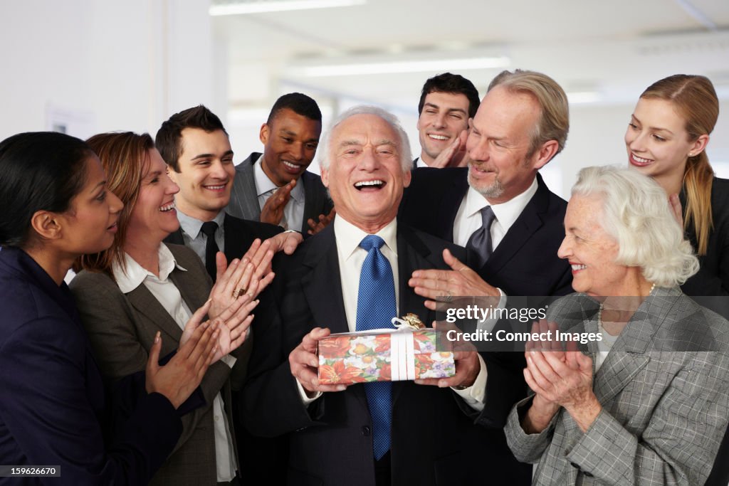 Colleagues giving gift to businessman