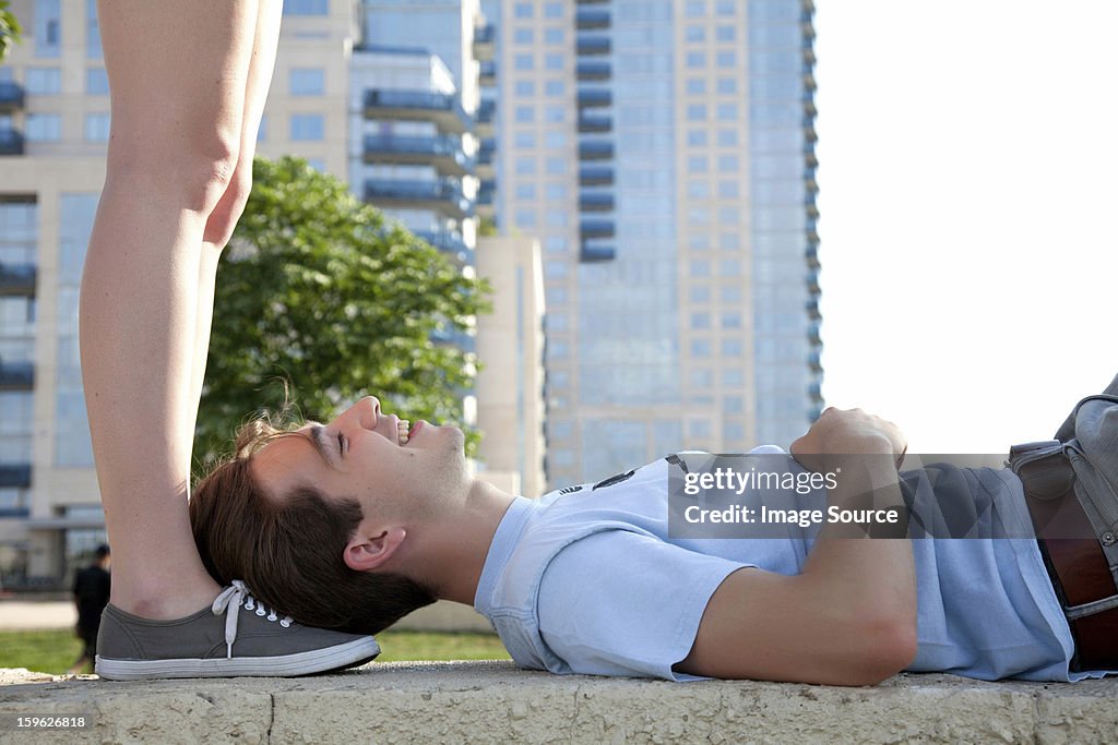 Young couple on wall, woman standing above man