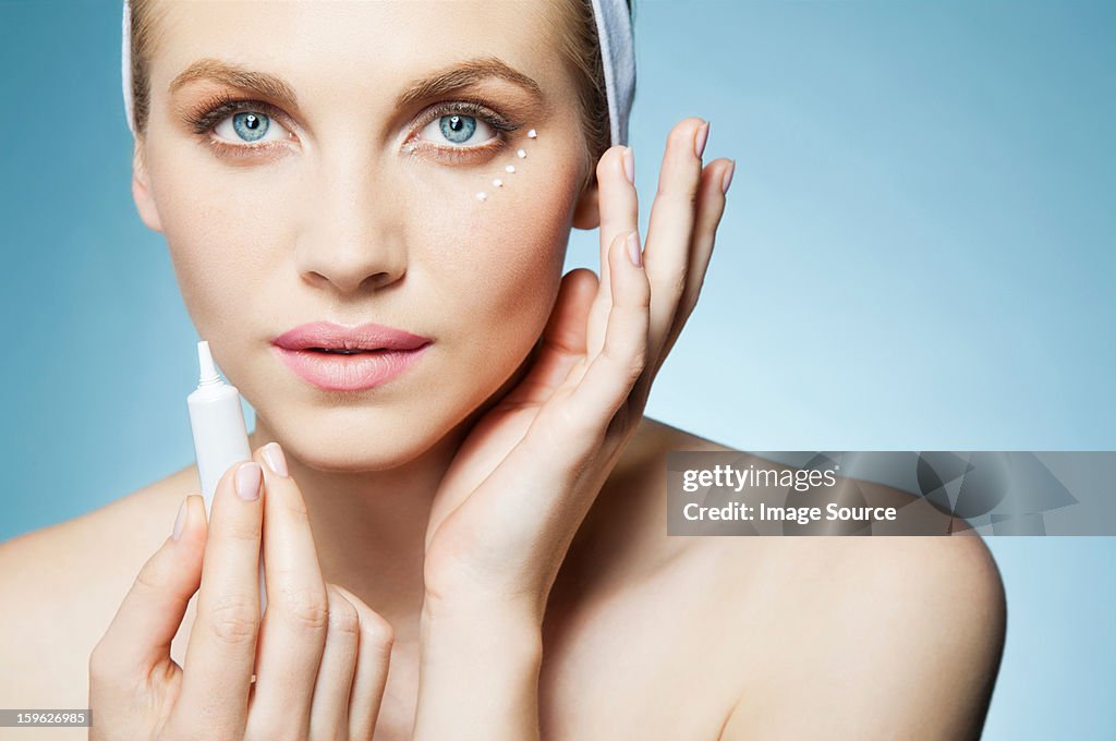 Woman applying eye cream