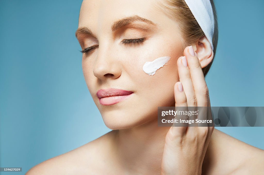 Woman applying moisturiser