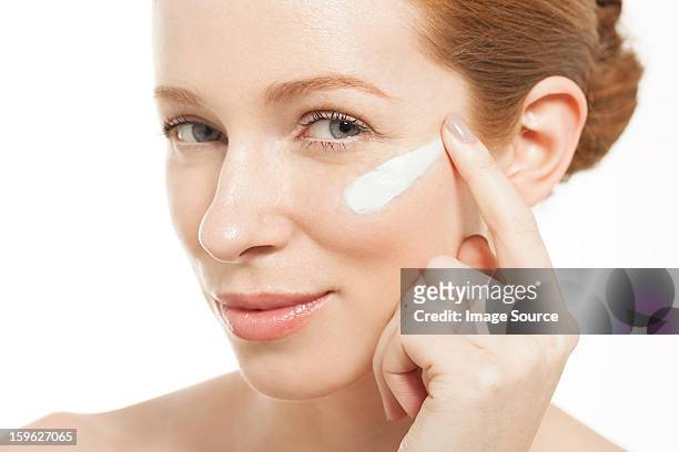 woman applying moisturiser - dito umano foto e immagini stock