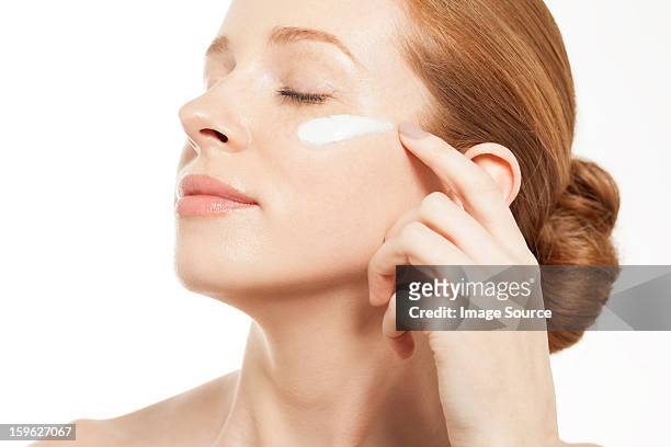 woman applying moisturiser with eyes closed - human finger stock pictures, royalty-free photos & images
