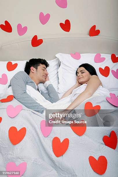 couple in bed with heart shapes on bedclothes - lastra a signa stock pictures, royalty-free photos & images