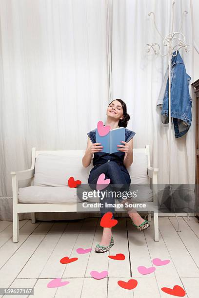 woman reading book with heart shapes - lastra a signa stock pictures, royalty-free photos & images