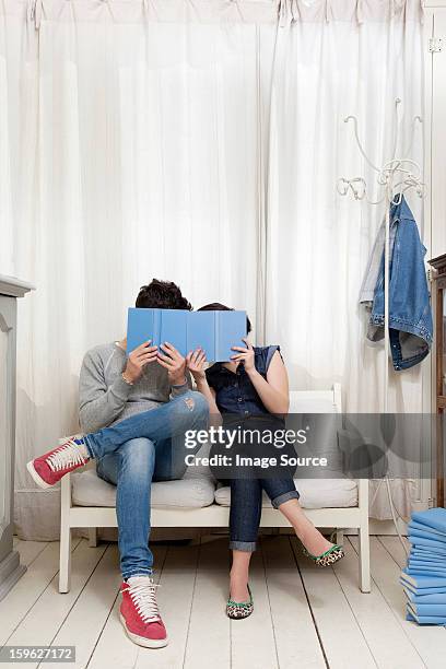 couple hiding behind books - lastra a signa stock pictures, royalty-free photos & images