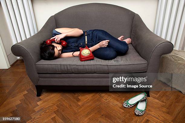 woman lying on sofa on the telephone - lastra a signa stock pictures, royalty-free photos & images