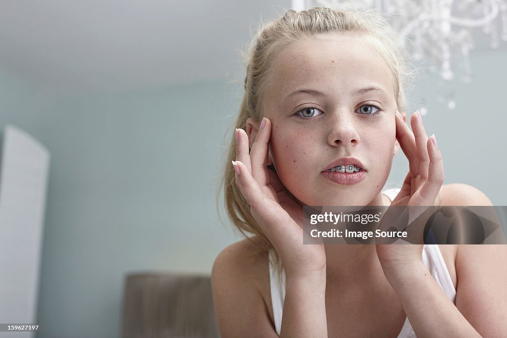 Teenage girl touching her face