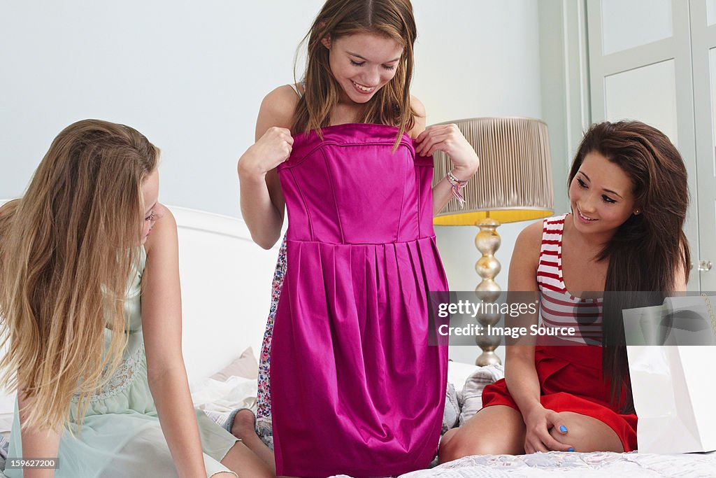 Teenage girl showing dress to friends