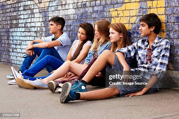 teenagers sitting against a wall - tag 14 photos et images de collection