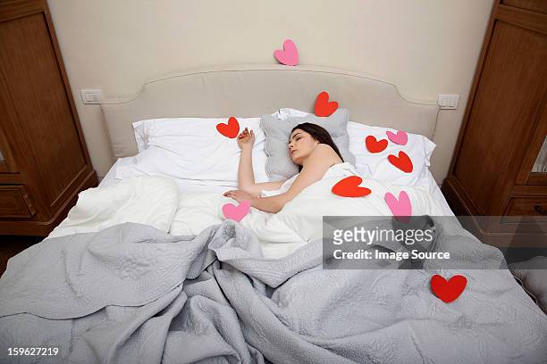 woman asleep in bed with heart shapes on bedclothes - lastra a signa stock pictures, royalty-free photos & images
