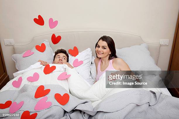 couple in bed with heart shapes on bedclothes - lastra a signa stock pictures, royalty-free photos & images