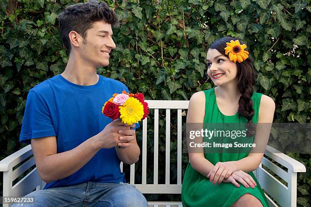 couple on bench, man holding flowers - lastra a signa stock pictures, royalty-free photos & images