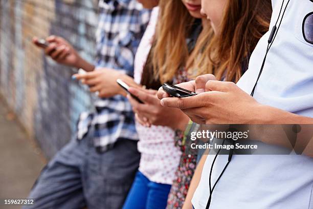 teenagers using cellphones - boys mobile phone group stock pictures, royalty-free photos & images