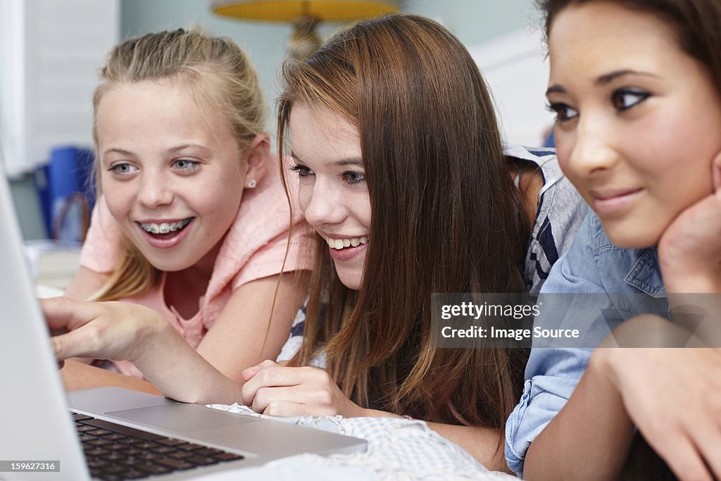 Teenage girls looking at laptop