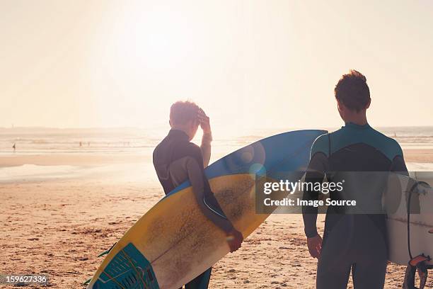 Surfers looking out towards sea