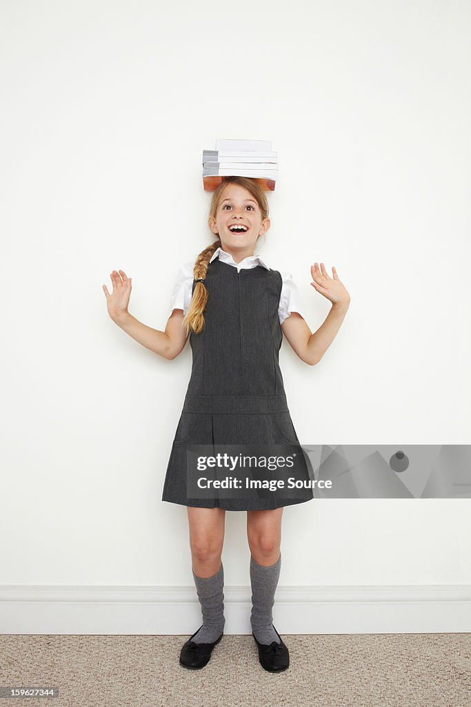 Schoolgirl balancing books on her head