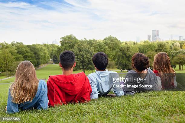 teenagers hanging out in a park - alleen tieners stockfoto's en -beelden