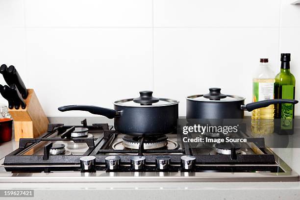 saucepans on gas hob - gaskookplaat stockfoto's en -beelden