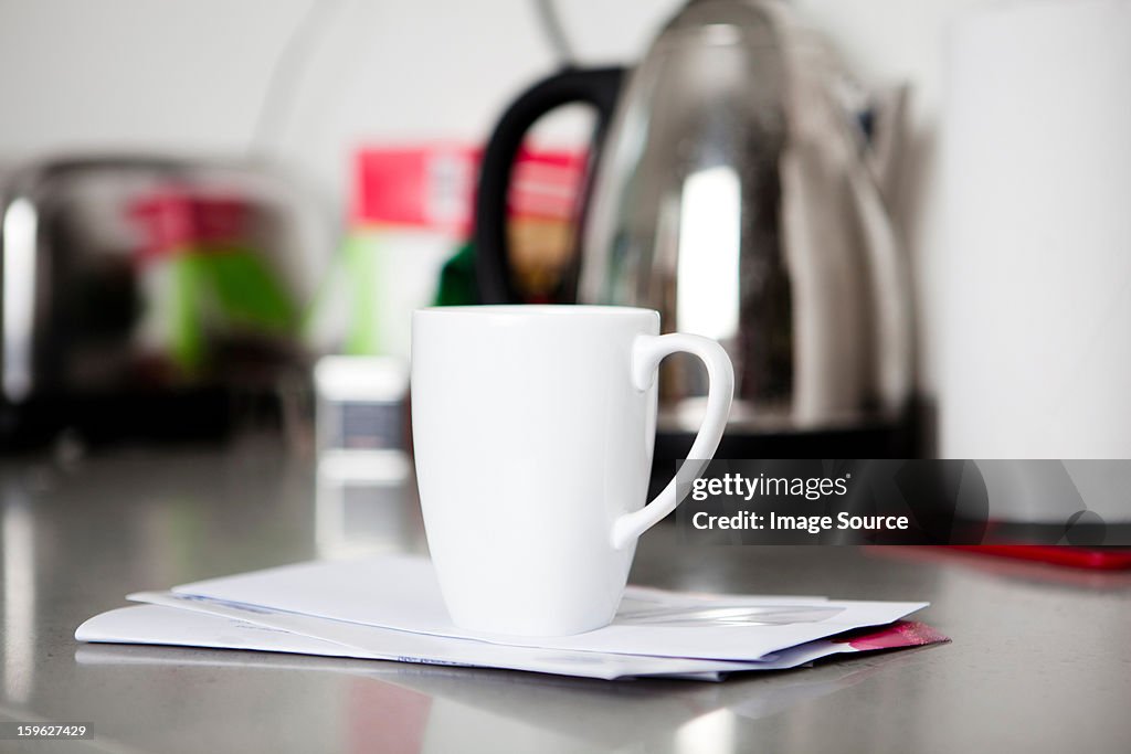 Coffee mug on top of envelopes