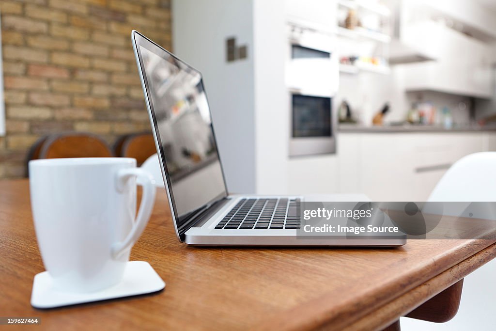 Laptop and mug on table