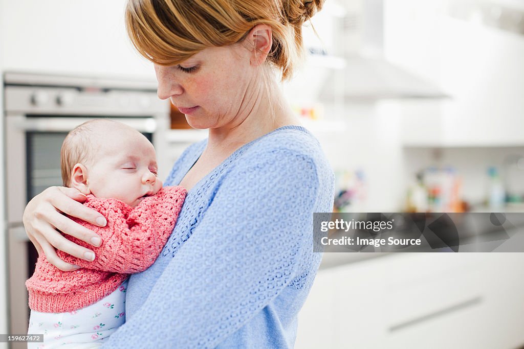 Mother holding newborn daughter