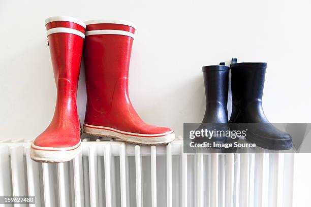 wellington boots on radiator - blue shoe foto e immagini stock