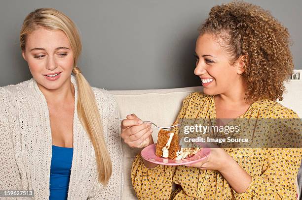 woman staring at friend eating cake - 輕蔑的 個照片及圖片檔