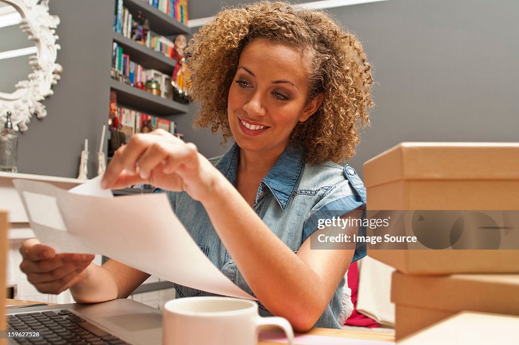 Woman sticking labels on cardboard boxes