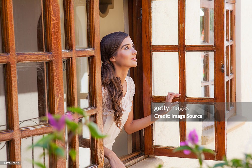 Young woman looking out of window