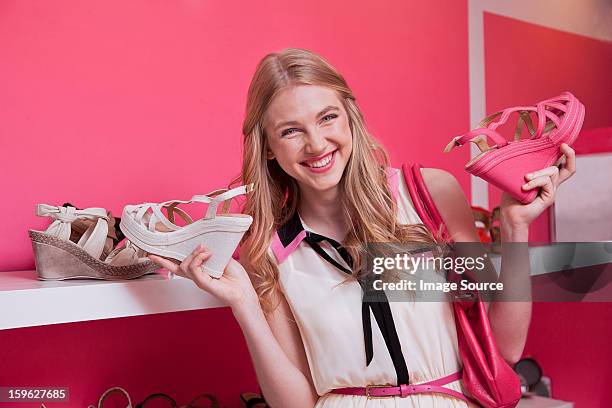 happy young woman holding shoes in store - furniture shopping stock pictures, royalty-free photos & images