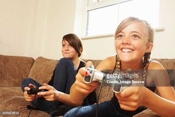 two girls playing video game - clip stock pictures, royalty-free photos & images