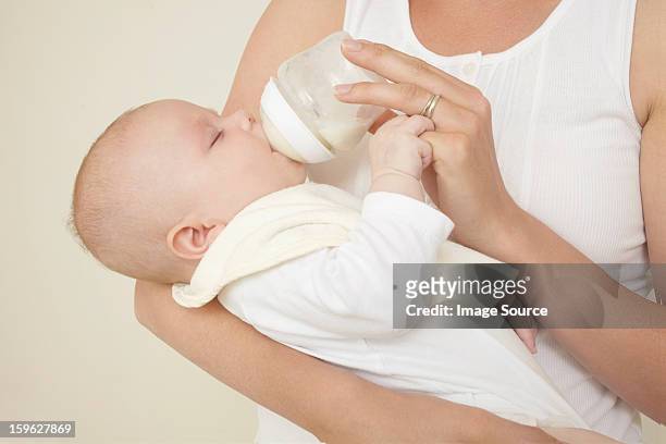 mother feeding newborn baby bottle of baby milk - baby studio bildbanksfoton och bilder
