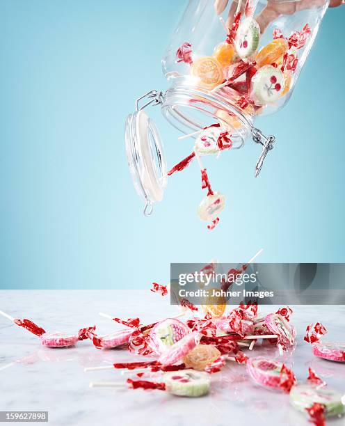 hand pouring small lollipops from jar - sweet jar stock pictures, royalty-free photos & images