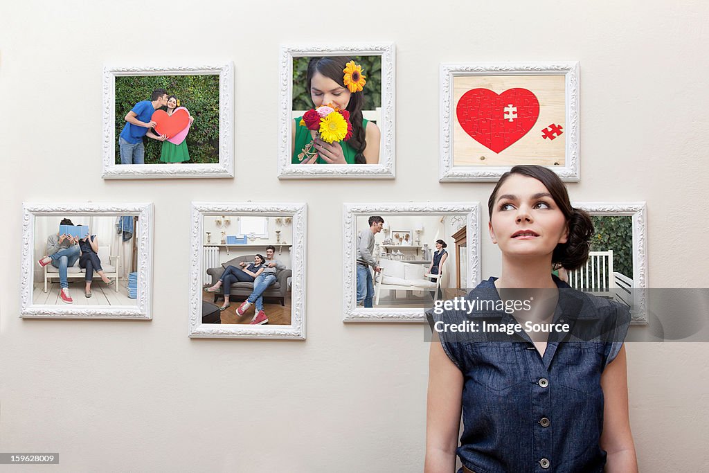 Young woman in front of wall of photographs