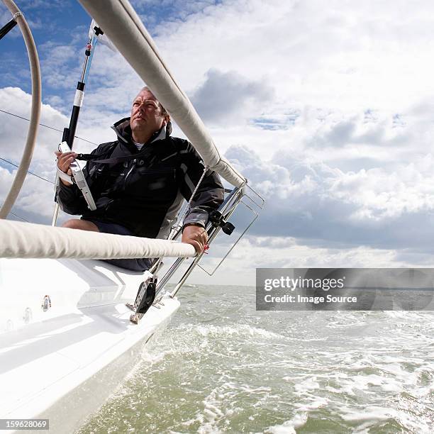 man on yacht, with navigation aid - boat gps stock-fotos und bilder