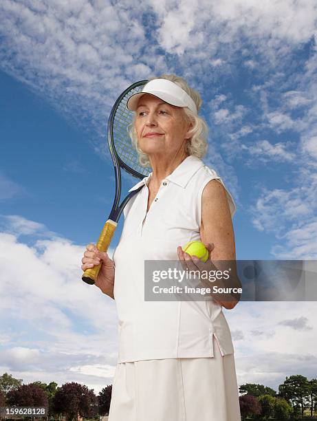 portrait of a senior woman with tennis gear - サンバイザー ストックフォトと画像