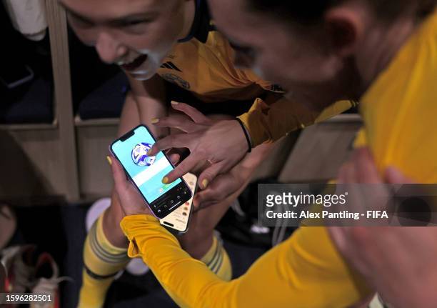 Players of Sweden look at a mobile phone in the dressing room the which displays the Video Assistant Referee goal line technology decision for the...
