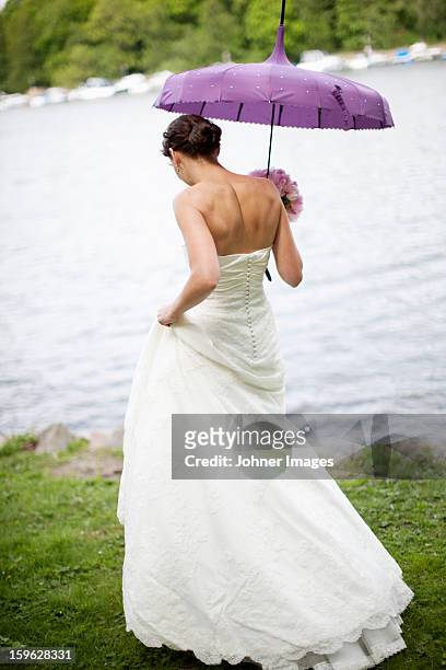 bride walking on lakeside - wedding umbrella stock pictures, royalty-free photos & images