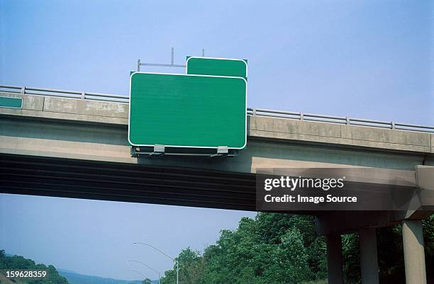 blank exit sign on highway overpass - street sign stockfoto's en -beelden