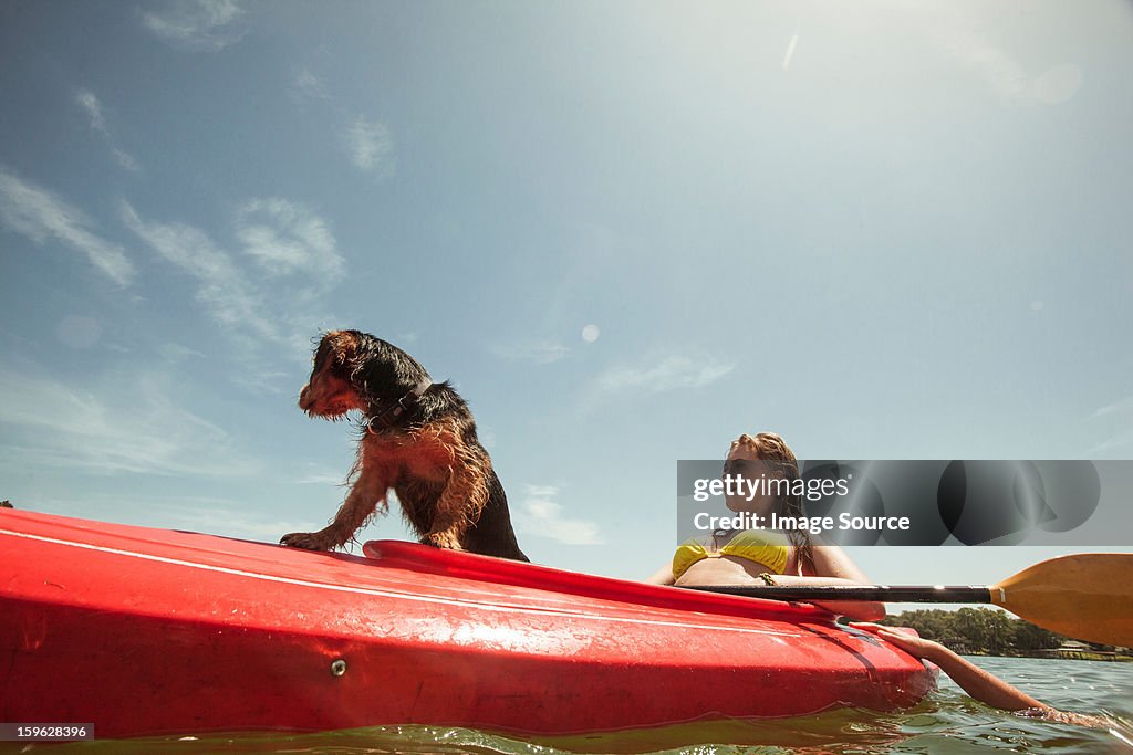 Teenage girl and pet dog in kayak