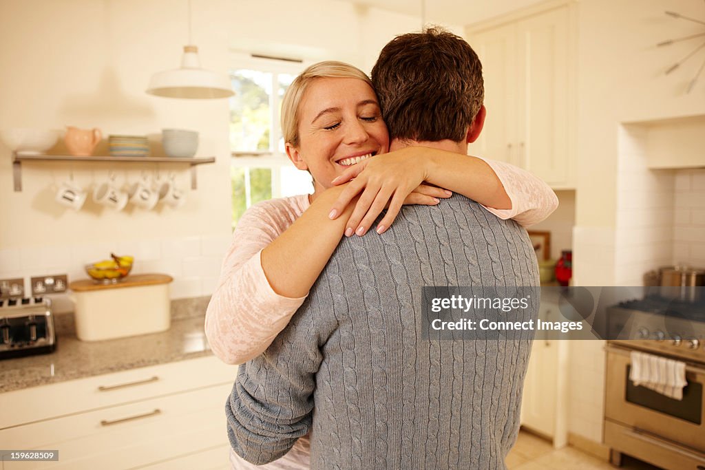 Couple hugging in kitchen