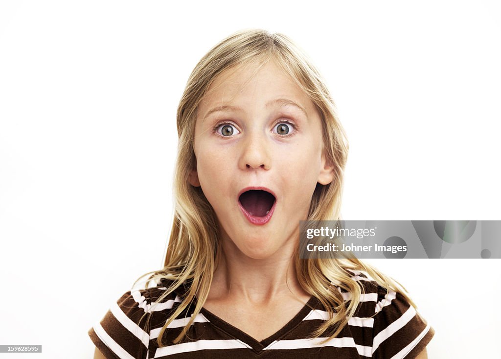 Portrait of smiling girl looking surprised, studio shot