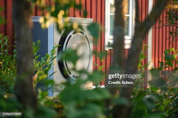 heat pump on a red house in the summer - wärmepumpe stock-fotos und bilder