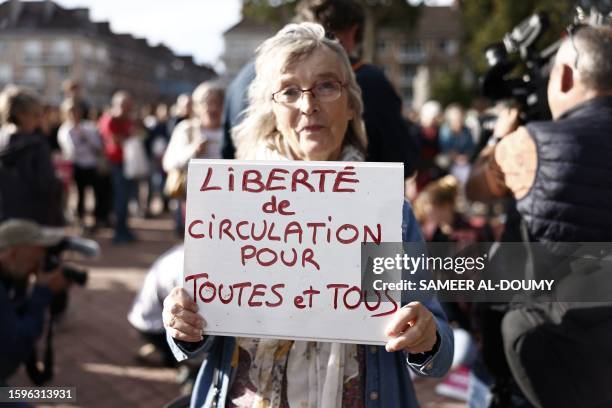 Woman holds a placard reading "Freedom of movement for everyone" during a rally in Calais, northern France, on August 13 after six people died after...