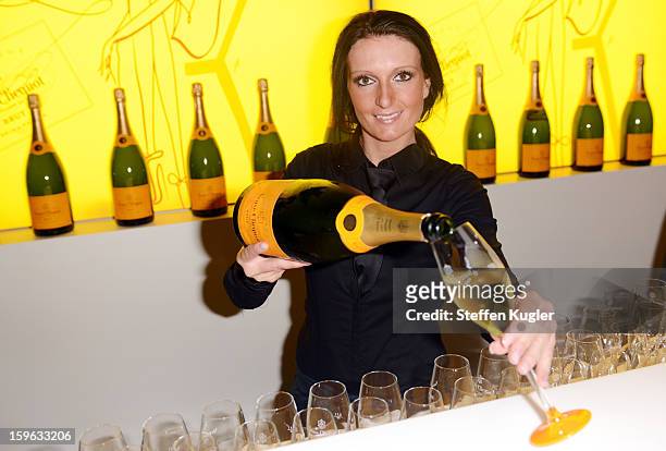 Waitress pours champagne into glasses at the Burda Style Group Cocktail on January 17, 2013 in Berlin, Germany.