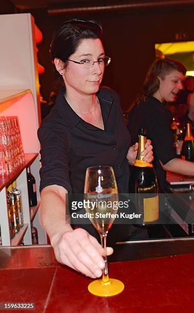 Waitress pours champagne into glasses at the Burda Style Group Cocktail on January 17, 2013 in Berlin, Germany.